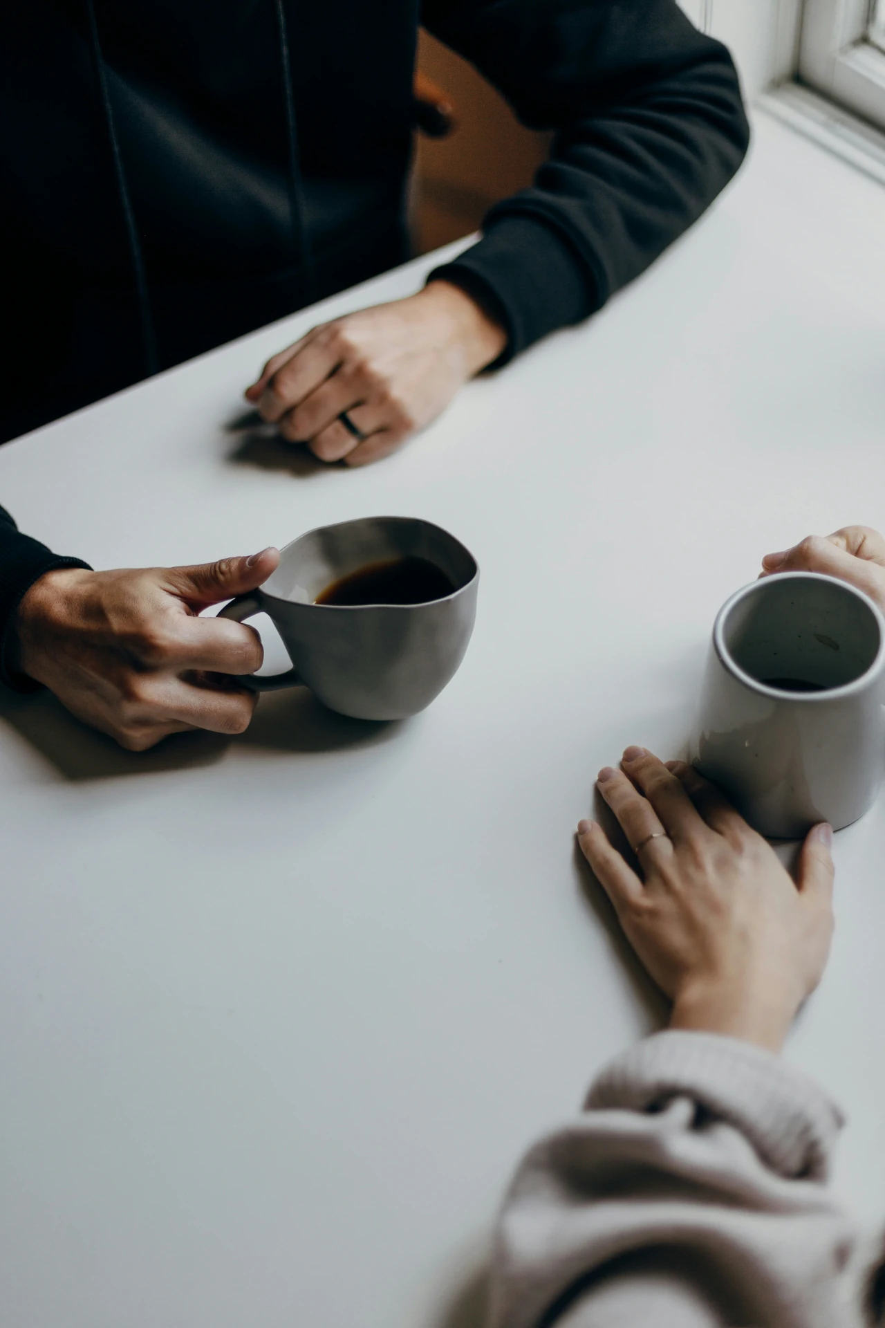 A couple sitting across a table with coffee